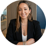 Mujer profesional con blazer sonriendo en oficina.